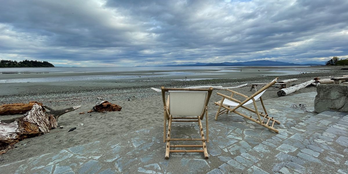 Two chairs facing the ocean by the beach in Parksville, BC
